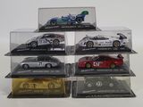 six model cars in a display case on a white surface