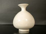 un vase blanc posé sur une table noire