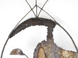 a metal sculpture of a man and a bird in a circle