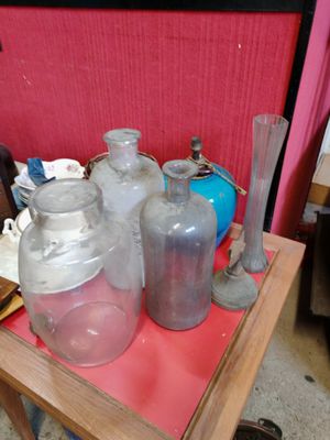 une petite table sur laquelle sont posées de nombreuses bouteilles en verre