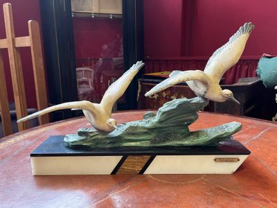 deux oiseaux qui volent au-dessus d'un livre posé sur une table