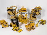 beaucoup de petits engins de chantier en jouets posés sur la table