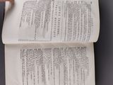 an overhead view of a person pointing at a book on a table