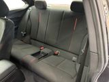 the back seats of a car are black with red stitching