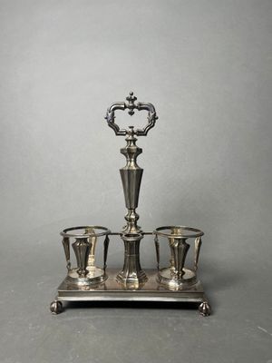 an antique silver plated tea set with four cups on a stand