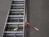 une échelle métallique sur laquelle est posée une paire de ciseaux