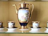 une étagère en verre sur laquelle sont posées des tasses et un vase