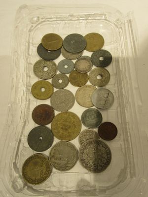 un récipient en plastique rempli d'une multitude de pièces de monnaie posé sur une table