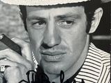 photographie en noir et blanc d'un homme coiffé d'un chapeau et fumant un cigare