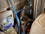 a picture of a bathroom with a toilet and a bucket of water