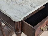 a marble top desk with a drawer underneath it