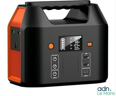 un chargeur portable orange et noir posé sur une surface blanche