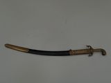 une vieille épée avec un manche en bois sur une surface blanche