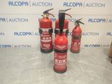 four red fire extinguisors are lined up on a counter