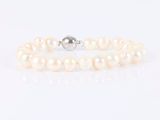 a white pearl bracelet with a silver clasp on a white background