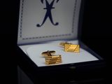 a box with two cufflinks and a ring in it