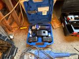 une boîte à outils bleue avec des outils sur le sol