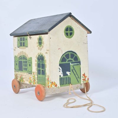 a small wooden toy house with a green door and windows
