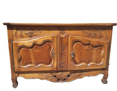 an image of a wooden cabinet with carvings on the doors