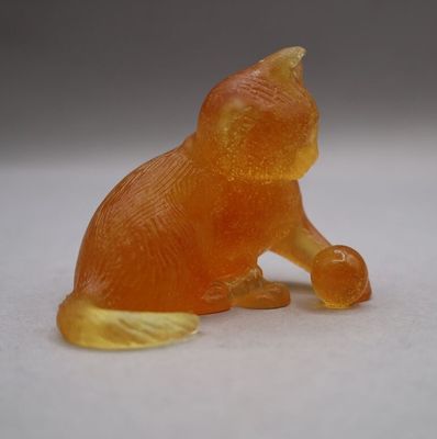 a small orange cat figurine sitting on a white surface