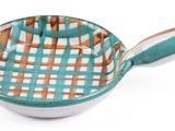 a green and white bowl with a handle on a white surface