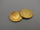 deux pièces d'or posées l'une sur l'autre sur une table
