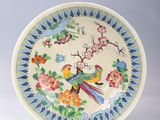 une assiette avec un oiseau et des fleurs