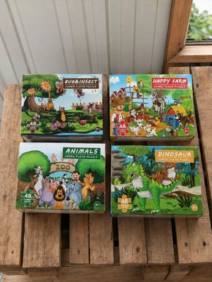trois livres de puzzles pour enfants posés sur une palette en bois