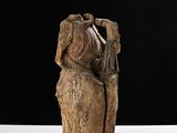 statue of a woman sitting on a rock with a cane in her hand