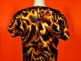 leopard print shirt on a mannequin stand against an orange wall