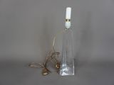 une bouteille en verre sur laquelle est fixée une lampe, reliée à un cordon