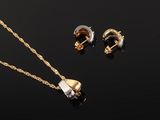 a gold necklace, earrings and ring set on a black background