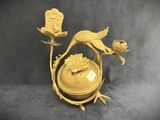 a gold vase with a bird and flowers on it