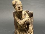 statue of a woman sitting on a rock holding a baby