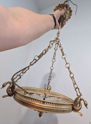 a person holding a clock hanging from a chain