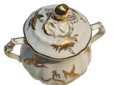 a white and gold pot with a gold lid