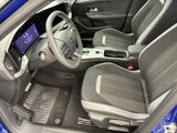 the interior of a blue car with a steering wheel and dashboard
