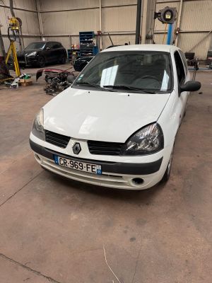 a white car parked in a garage with other cars in the background