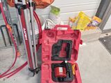 une boîte à outils rouge posée par terre à côté d'un porte-outils
