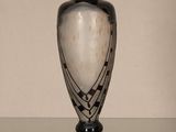 a black and white vase sitting on a glass table