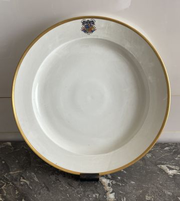 a close up of a white plate with gold trim on a marble surface