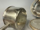 a silver plate with a spoon and a silver plate with a silver plate with a spoon and a silver plate with a spoon and a silver plate with a