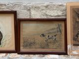trois tableaux encadrés accrochés à un mur de pierre, à côté d'un mur de pierre