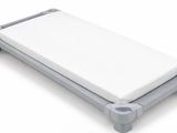 un petit lit sur lequel est posé un matelas blanc