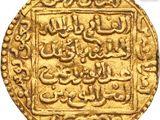 a close up of a gold coin with arabic writing on it