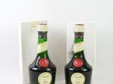 deux bouteilles d'alcool posées l'une à côté de l'autre sur une surface blanche
