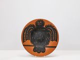 une assiette orange et noire ornée d'un motif représentant un hibou