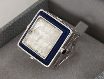 une image représentant une bague argentée et bleue sur laquelle figure le portrait d'une femme