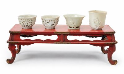 une table rouge sur laquelle sont posés trois bols