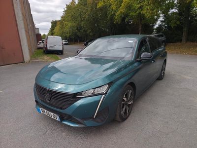 La voiture bleue est garée sur le parking, à côté d'un immeuble.
